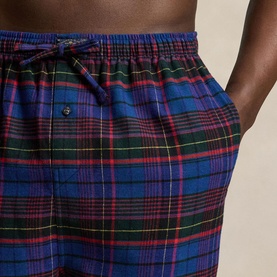 Model wearing blue, green and red tartan check lounge shorts with elasticated drawstring waist and side pockets