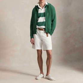 Model wearing Ralph Lauren Verano Green zip-up hoodie with white striped polo, white shorts, and white trainers.