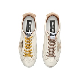 Golden Goose white leather trainers, top-down view showing taupe star detail, yellow laces on one shoe and brown laces on the other