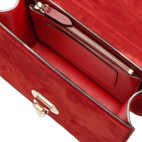 Red suede and leather bag interior showing zip pocket, card slots, and gold-tone hardware detail