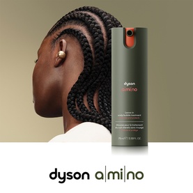 Model with Dyson Amino leave-in spray treatment beside updo braided hairstyle, green and orange bottle shown alongside