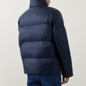 Model wearing Calvin Klein Logo Badge Padded Jacket in Dark Sapphire, rear view showing quilted panels, stand collar and zip pockets, styled with