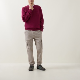 Model wearing Calvin Klein 350 Logo Sweatshirt in Rhododendron, styled with grey cargo trousers and black trainers.