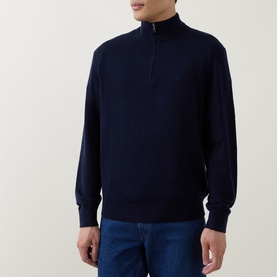 Model wearing Calvin Klein Monogram Logo Half-Zip Sweater in Dark Sapphire, funnel neck, tonal chest logo, styled with blue jeans.