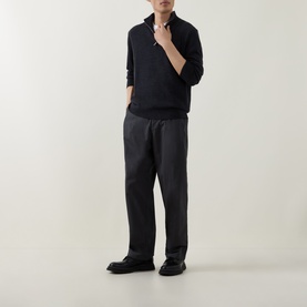 Model wearing Calvin Klein Monogram Logo Half-Zip Sweater in Gunmetal Heather with grey wide-leg trousers and black loafers
