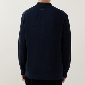 Model wearing Calvin Klein Badge Logo Textured Polo Sweater in Black, rear view showing textured knit and logo detail