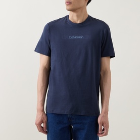 Model wearing Calvin Klein Graphic Logo T-Shirt in Blue Nights, crew neck, short sleeves, contrast logo lettering, styled with blue jeans