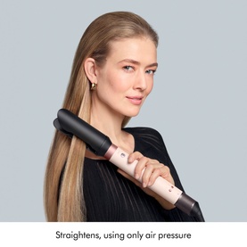 Model with Dyson Coanda 2x Ceramic Apricot hair straightener styling long blonde hair, wearing black top