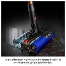 Dyson cordless vacuum cleaner close-up showing blue motorised floor head with rotating roller bar and transparent dust compartment.