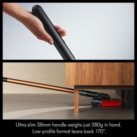 Dyson cordless vacuum with ultra-slim 38mm black handle shown in hand above, and low-profile red cleaner head reaching under furniture below.
