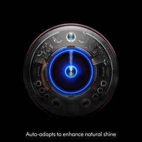 Close-up of a Dyson hair tool power button with glowing blue light, with text: Auto-adapts to enhance natural shine