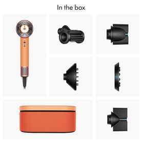 Dyson Supersonic hair dryer in coral orange with dark attachments and matching storage case, showing full in-the-box contents