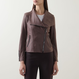 Model wearing Joseph Ribkoff Jacket in mink, featuring asymmetric zip fastening, draped collar, and slim fit styling with dark trousers.