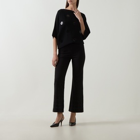 Model wearing Joseph Ribkoff Sequin Embellished Knitted Sweater in black with boat neck and short sleeves, styled with black wide-leg trousers and
