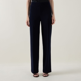 Model wearing Joseph Ribkoff midnight blue wide-leg trousers with front crease detail, styled with black heeled sandals