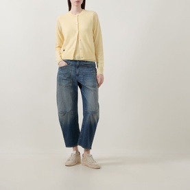Model wearing Lucy Nagle The Everyday Cardigan in Primrose, styled with blue barrel-leg jeans and beige trainers.