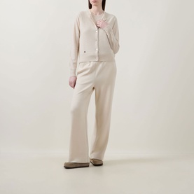 Model wearing Lucy Nagle The Everyday Cardigan in Pearl, fine knit with logo disc detail, styled with matching wide-leg trousers and flat loafers.