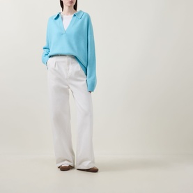 Model wearing Lucy Nagle The Cashmere Collar Sweater in Bambino blue with notched neckline, styled with wide-leg white trousers.