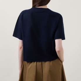 Model wearing Lucy Nagle The Cashmere Top in Midnight Slate, back view, crew neck, short sleeves, ribbed trims, styled with khaki midi skirt.