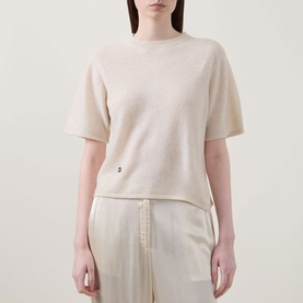 Model wearing Lucy Nagle The Cashmere Top in Pearl, crew neck, short sleeves, dropped shoulders, small logo disc detail, styled with cream wide-leg