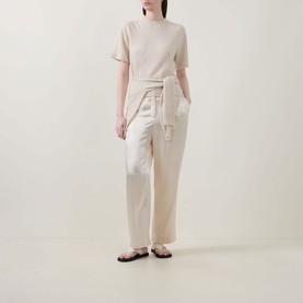 Model wearing Lucy Nagle The Cashmere Top in Pearl with crew neck and short sleeves, styled with white wide-leg trousers and dark sandals.
