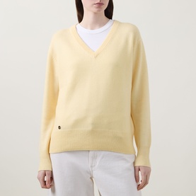 Model wearing Lucy Nagle The Elevated Cashmere Sweater in Primrose, V-neck, long sleeves, dropped shoulders, styled with white tee and white jeans