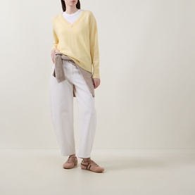 Model wearing Lucy Nagle The Elevated Cashmere Sweater in Primrose, V-neck fine knit, styled with white jeans and a layered shirt