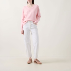Model wearing Lucy Nagle The Elevated Cashmere Sweater in Crystal Rose, V-neck, dropped shoulders, styled with white straight-leg jeans and nude flat