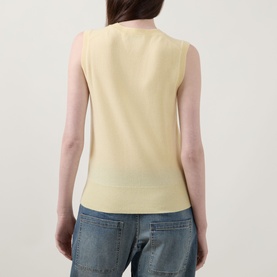 Model wearing Lucy Nagle The Crew Cashmere Top in Primrose, sleeveless fine knit with ribbed trims, styled with blue denim jeans. Rear view.