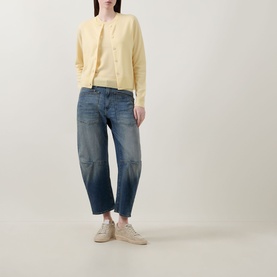 Model wearing Lucy Nagle The Crew Cashmere Top in Primrose, sleeveless fine knit, styled with yellow cardigan, blue barrel-leg jeans and cream