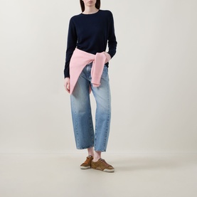 Model wearing Lucy Nagle The Everyday Cashmere Sweater in Midnight Slate, styled with light-wash wide-leg jeans and a pink shirt tied at the waist
