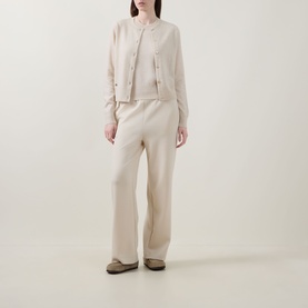 Model wearing Lucy Nagle The Crew Cashmere Top in Pearl, sleeveless fine knit, styled with matching cream cardigan and wide-leg trousers.