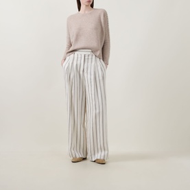 Model wearing Lucy Nagle The Stitch Cashmere Sweater in Light Weight Beige with white striped wide-leg trousers and beige shoes.