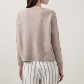 Model wearing Lucy Nagle The Stitch Cashmere Sweater in Light Weight Beige, back view showing stitch detail at sleeve seams, styled with striped