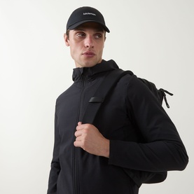 Model with Lululemon Classic Wordmark Ball Cap in black, styled with a black zip-up hooded jacket and backpack.