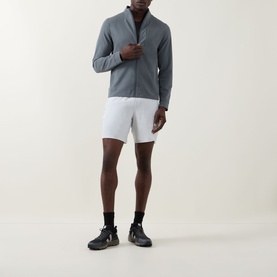 Model wearing Lululemon Sojourn Jacket in Onyx Grey, styled with white shorts, black socks and dark trainers