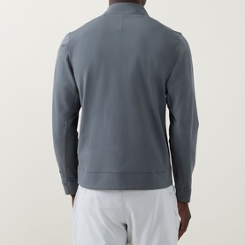 Model wearing Lululemon Sojourn Jacket in Onyx Grey, rear view, with light grey shorts. Clean back seam detail, ribbed hem and cuffs.