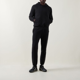 Model wearing Lululemon black hoodie, styled with matching black joggers and black chunky-sole shoes.