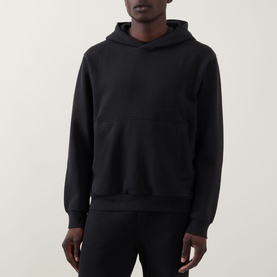Model wearing Lululemon black pullover hoodie with kangaroo pocket, styled with matching black joggers.