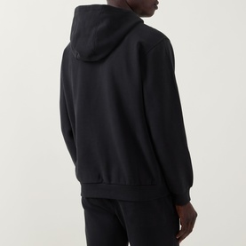 Model wearing Lululemon black hoodie, rear view, with matching black joggers
