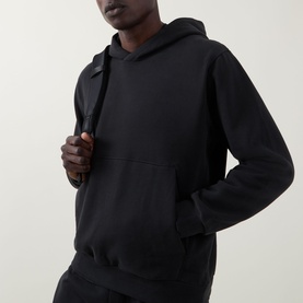 Model wearing Lululemon black pullover hoodie with kangaroo pocket, styled with matching black joggers