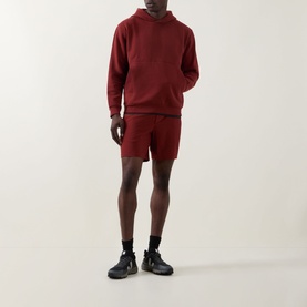 Model wearing Lululemon Cranberry Charm hoodie with matching shorts, styled with black socks and dark trainers.