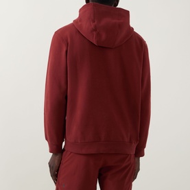 Model wearing Lululemon hoodie in Cranberry Charm, rear view, with matching joggers. Relaxed fit with hood and kangaroo pocket.