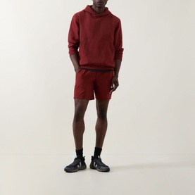 Model wearing Lululemon hoodie and matching shorts in Cranberry Charm, styled with black socks and dark trainers.