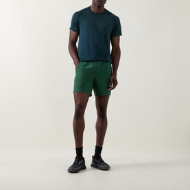 Model wearing Lululemon Green Cove performance shorts with teal T-shirt and black trainers