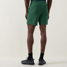 Model wearing Lululemon Green Cove performance shorts, rear view, styled with black socks and dark trail trainers