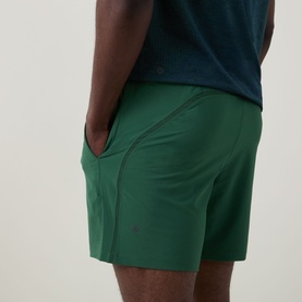 Model wearing Lululemon Green Cove performance shorts with side seam detail, styled with a navy T-shirt
