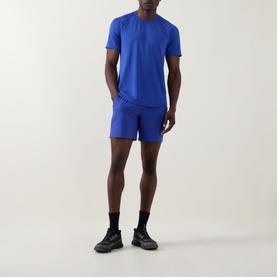 Model wearing Lululemon Pace Breaker Linerless Shorts 7" in Beach Ball Blue, styled with matching blue tee and black socks and trainers.