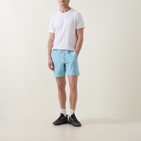 Model wearing Lululemon seafoam performance shorts with white T-shirt and black trainers with white socks