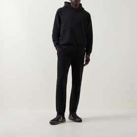 Model wearing Lululemon black sweatpants, styled with a matching black hoodie and dark trainers.